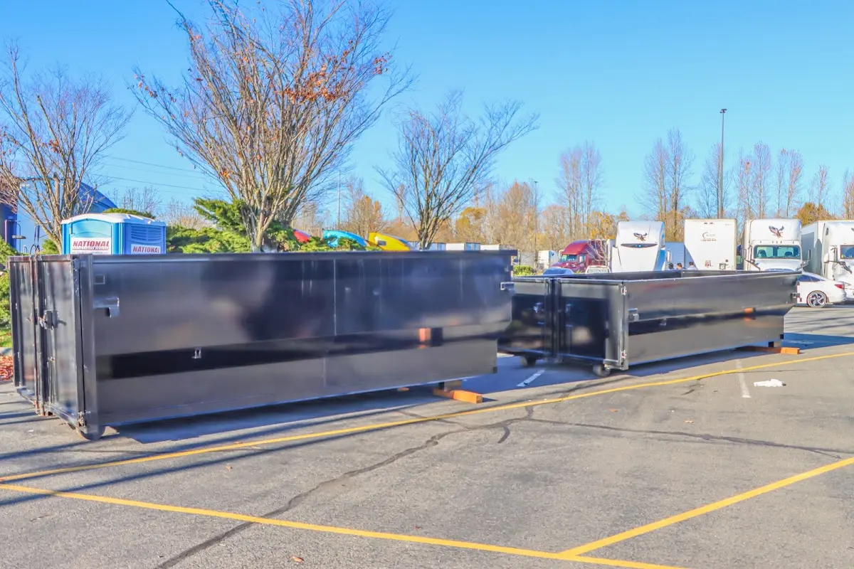 Professional dumpster rental service with roll-off container on residential driveway in Fruitport